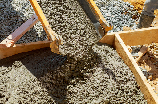 Truck mixer pouring concrete cement into a concrete with sidewalk